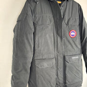 Canada Goose black parka jacket with logo patch and fur-lined hood.
