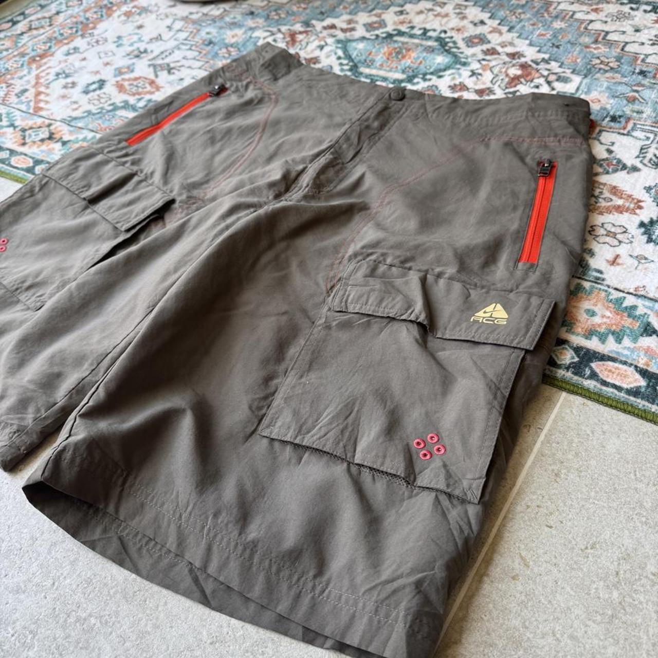 Nike ACG grey cargo shorts with multiple pockets and embroidered logo detail.