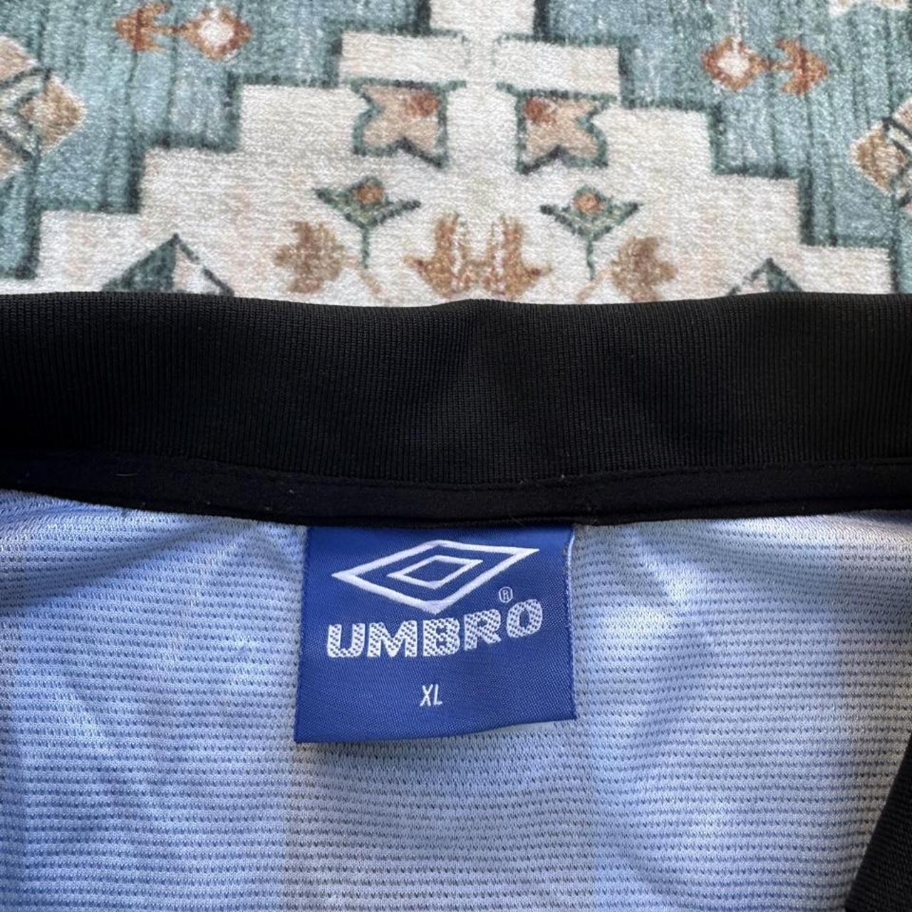 Umbro blue and navy striped home jersey with embroidered logo and vintage design.