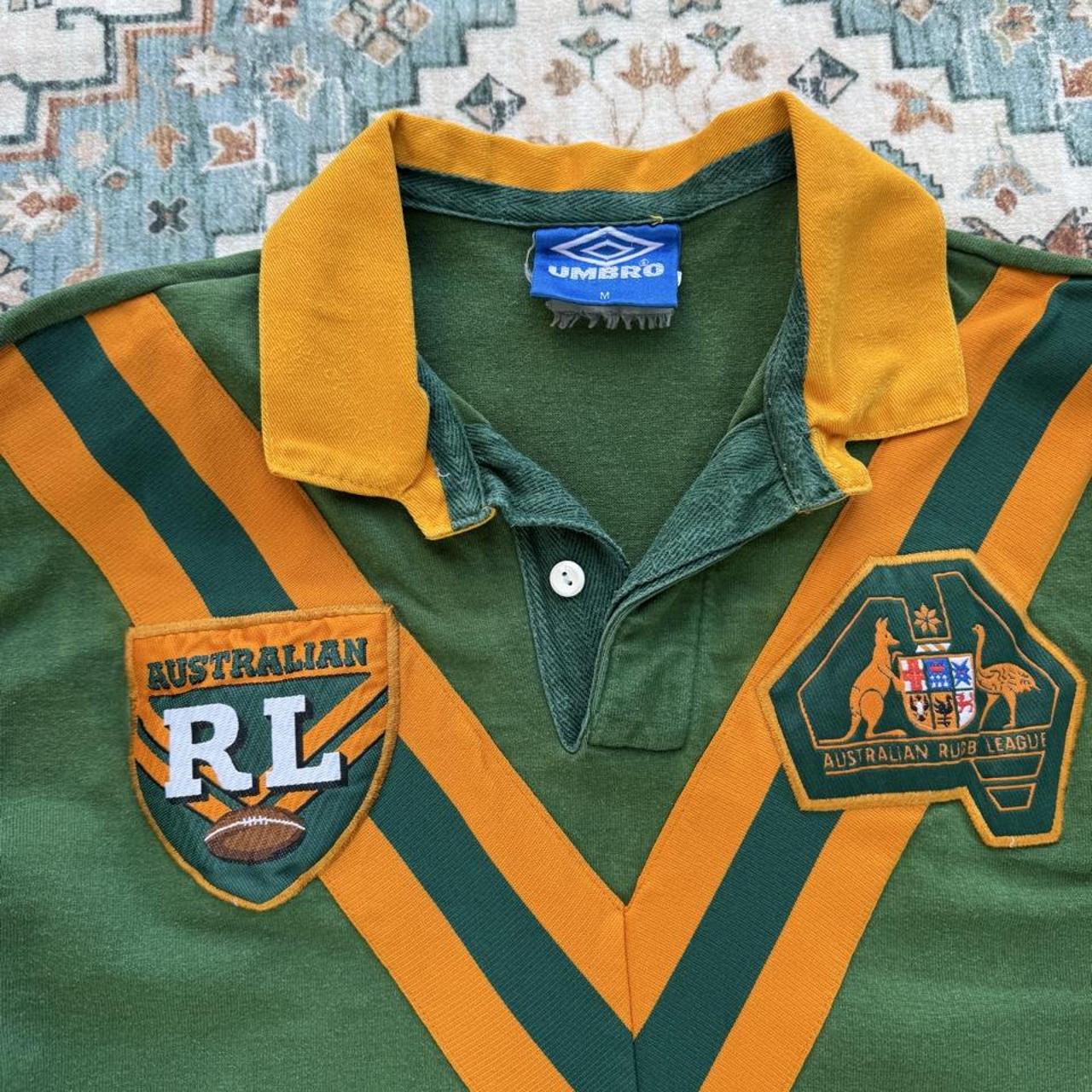 Umbro men's polo shirt green with Wallabies logo and rugby league pattern.