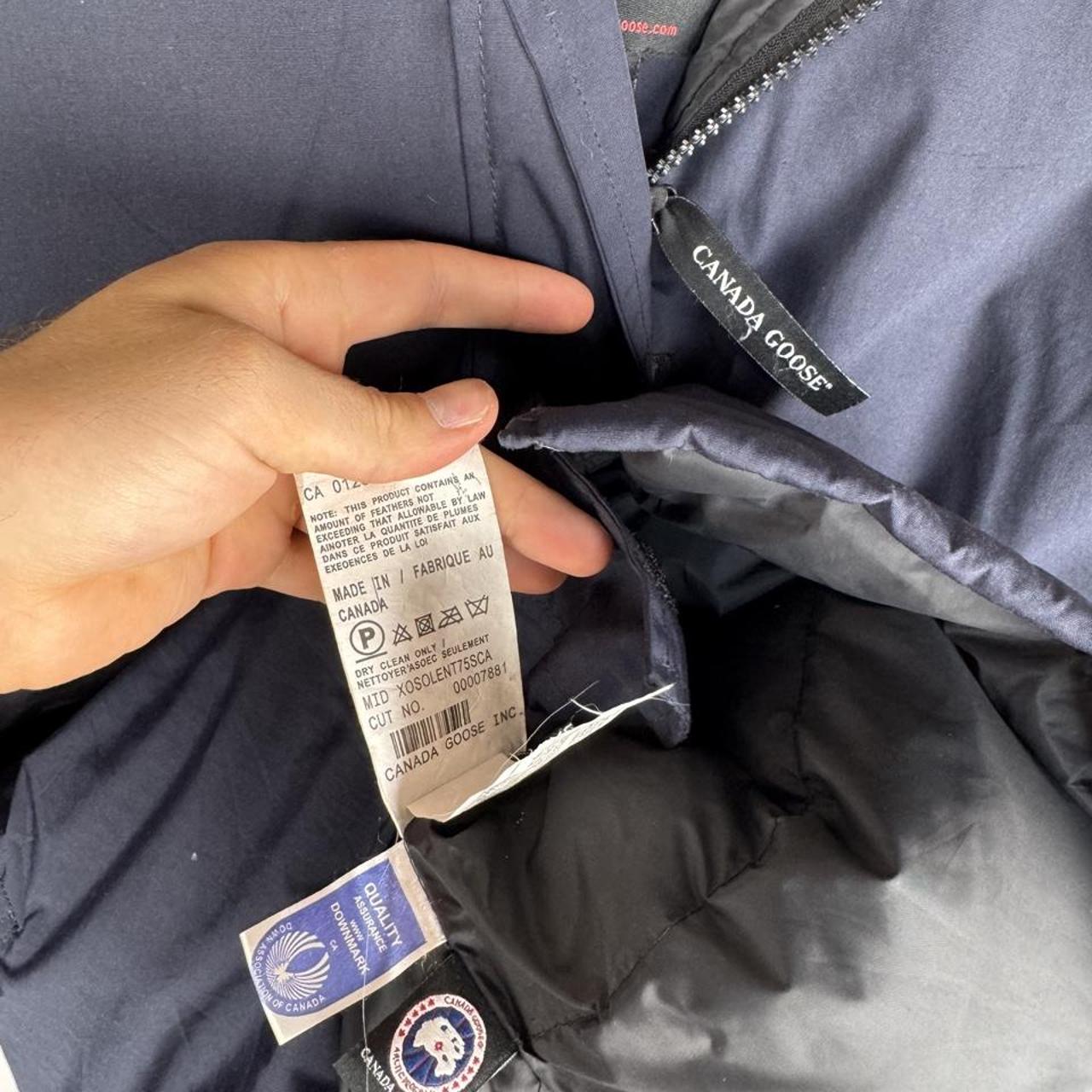 Canada Goose navy parka jacket with logo patch and fur-lined hood.