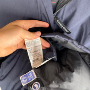 Canada Goose navy parka jacket with logo patch and fur-lined hood.