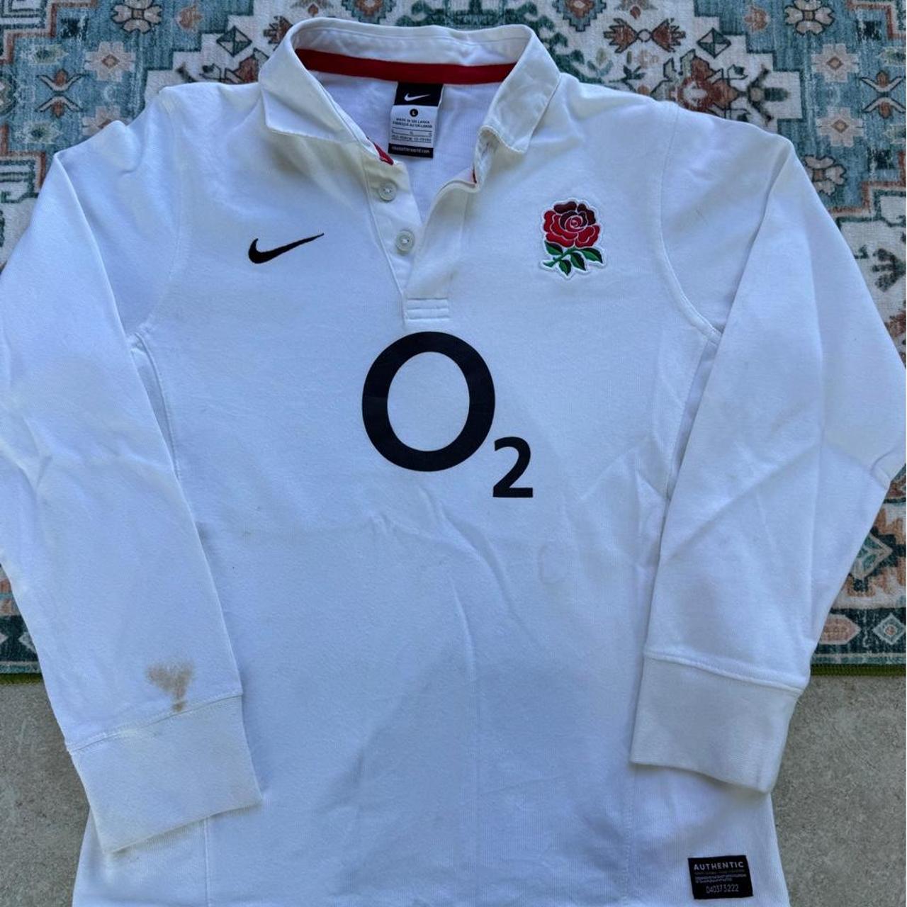 Nike black and white rugby polo shirt with England logo and striped pattern.