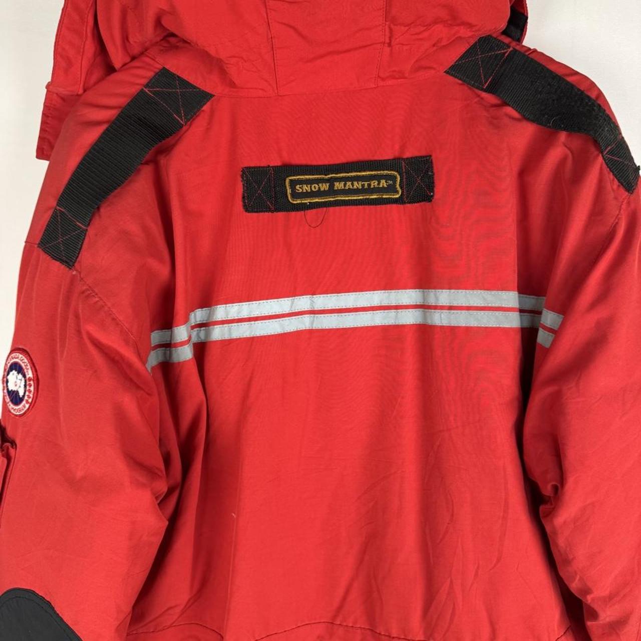 Canada Goose red parka jacket with logo patch and thick insulated material.