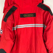 Canada Goose red parka jacket with logo patch and thick insulated material.