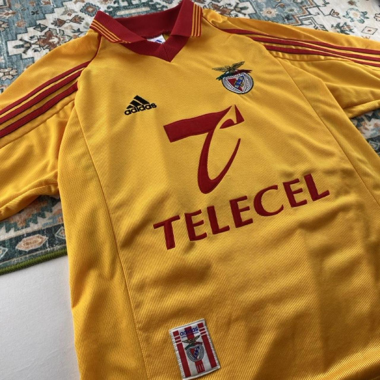 Adidas orange Benfica away jersey with embroidered logo and vintage design details.