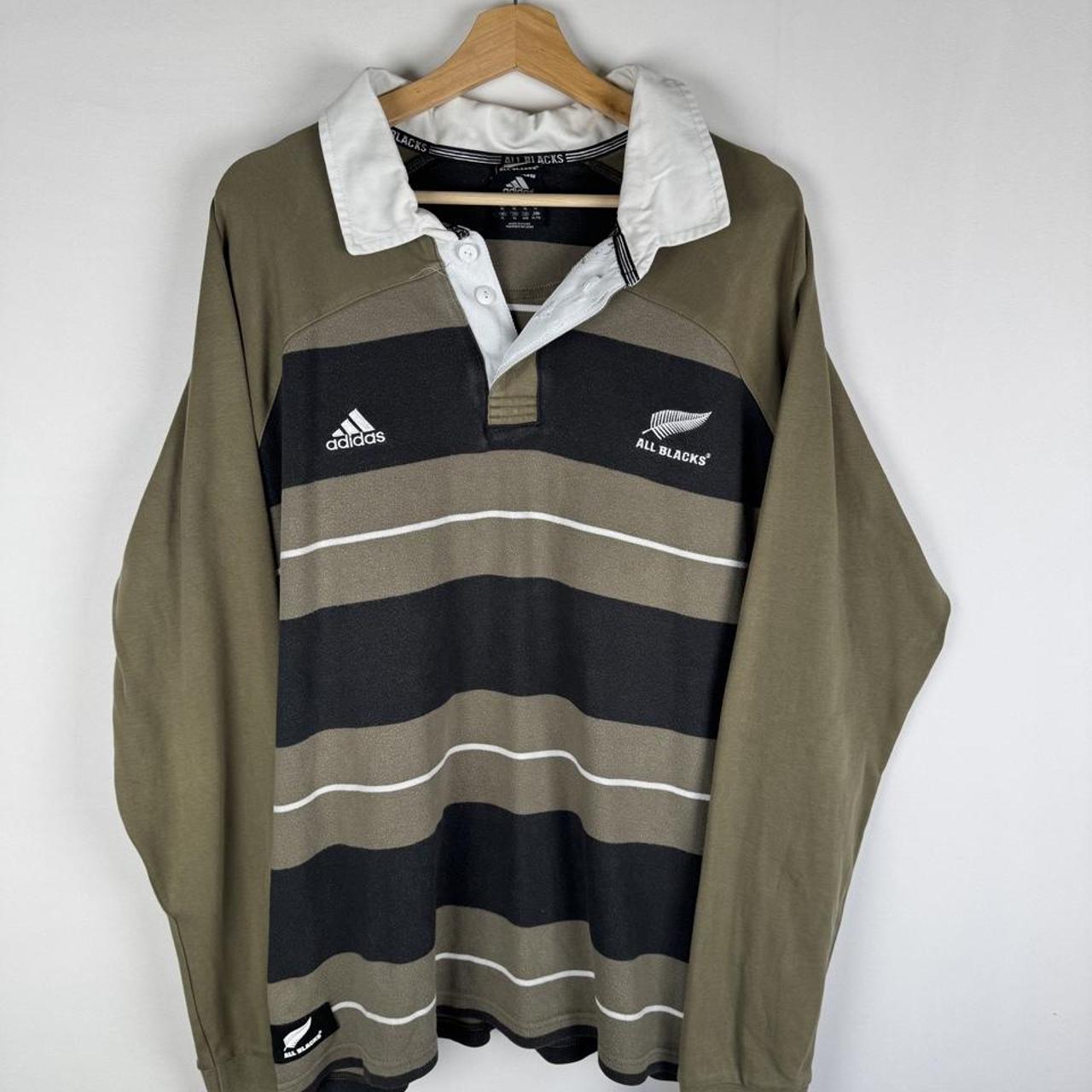 Adidas cream rugby polo with striped pattern and New Zealand All Blacks logo.