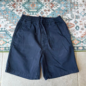 Carhartt WIP navy shorts with logo patch and durable cotton material.