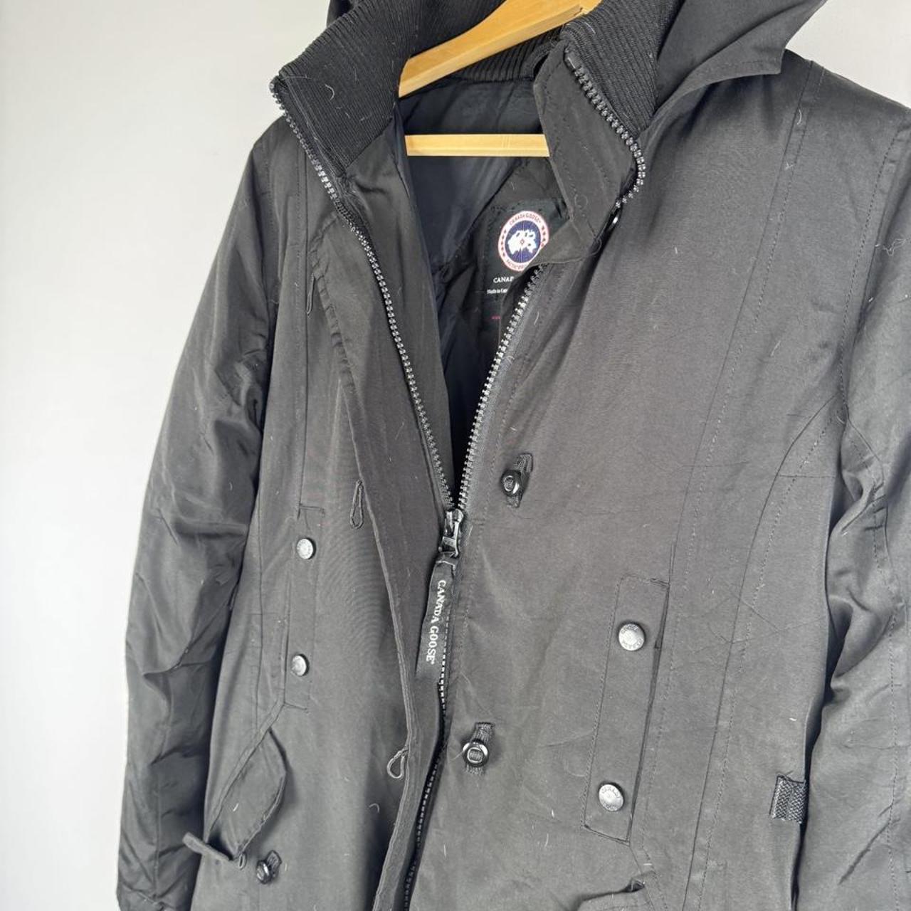 Canada Goose black parka jacket, medium size, features logo patch and sleek design.