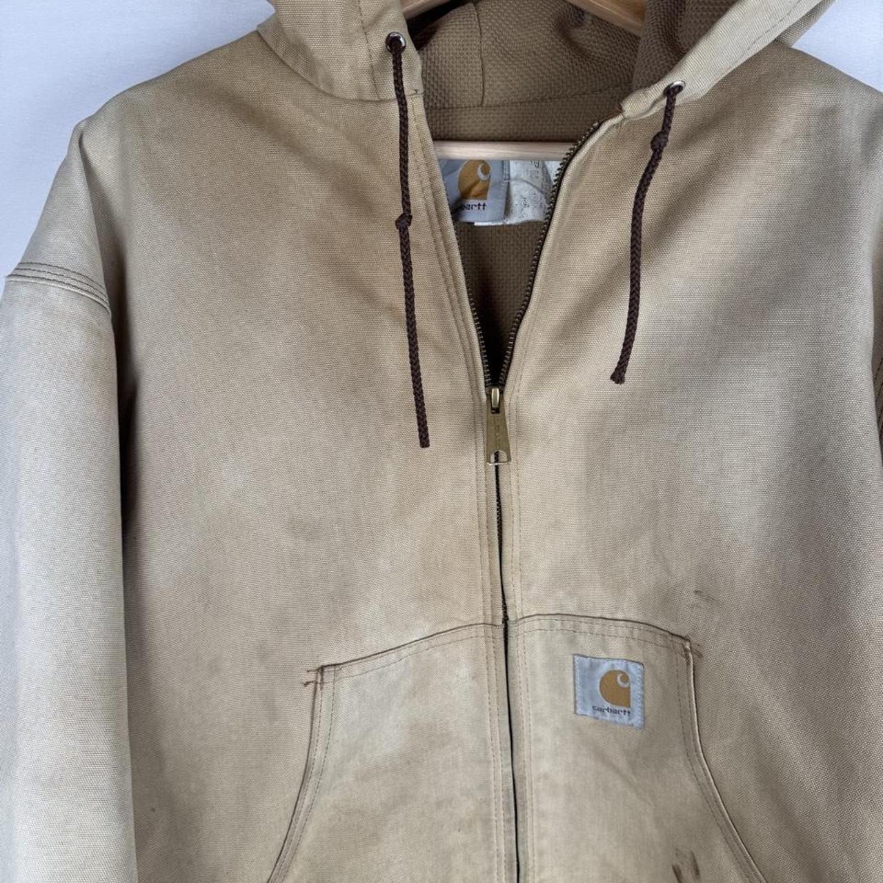Carhartt cream distressed active jacket with logo patch and relaxed fit.