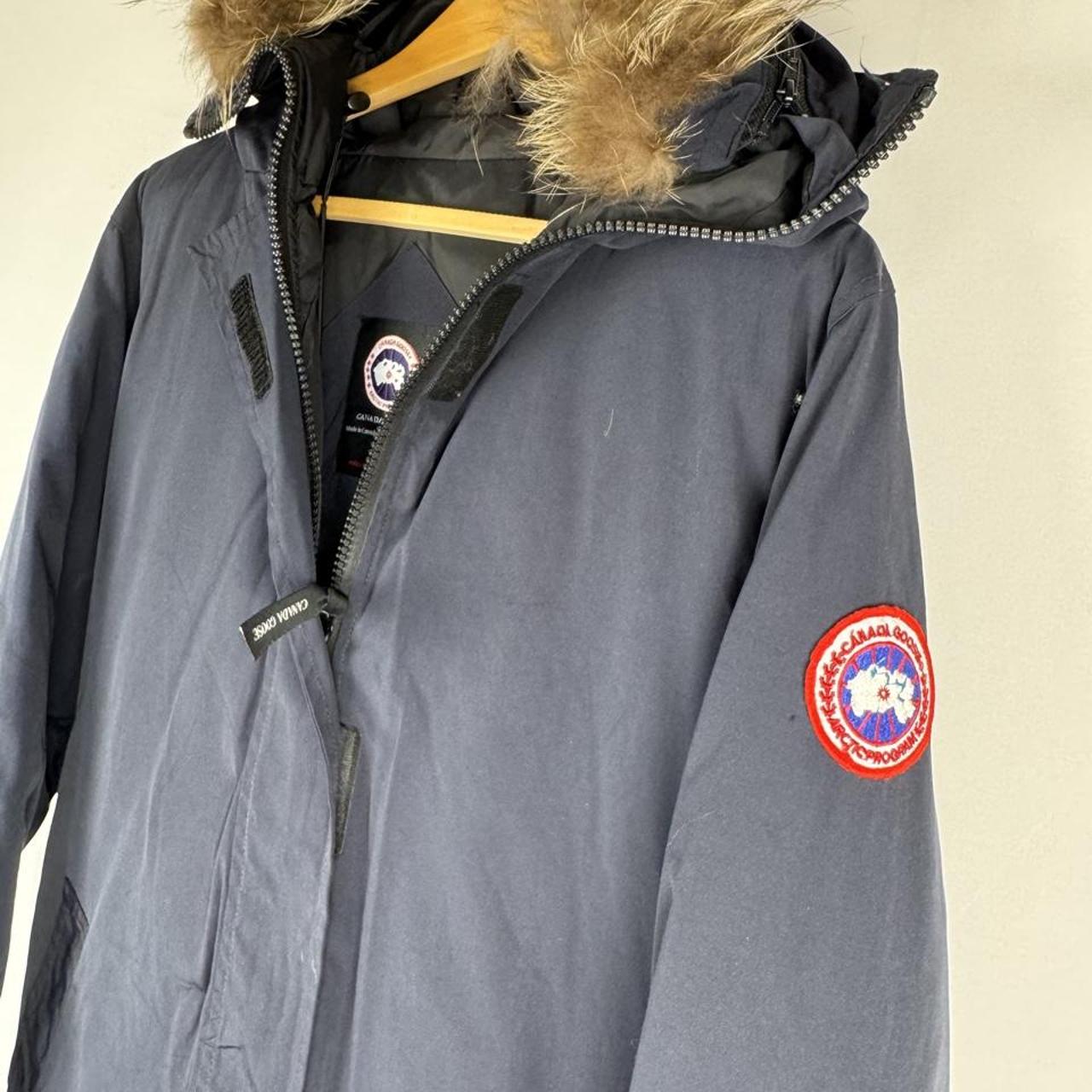 Canada Goose navy parka jacket with logo patch and fur-lined hood.