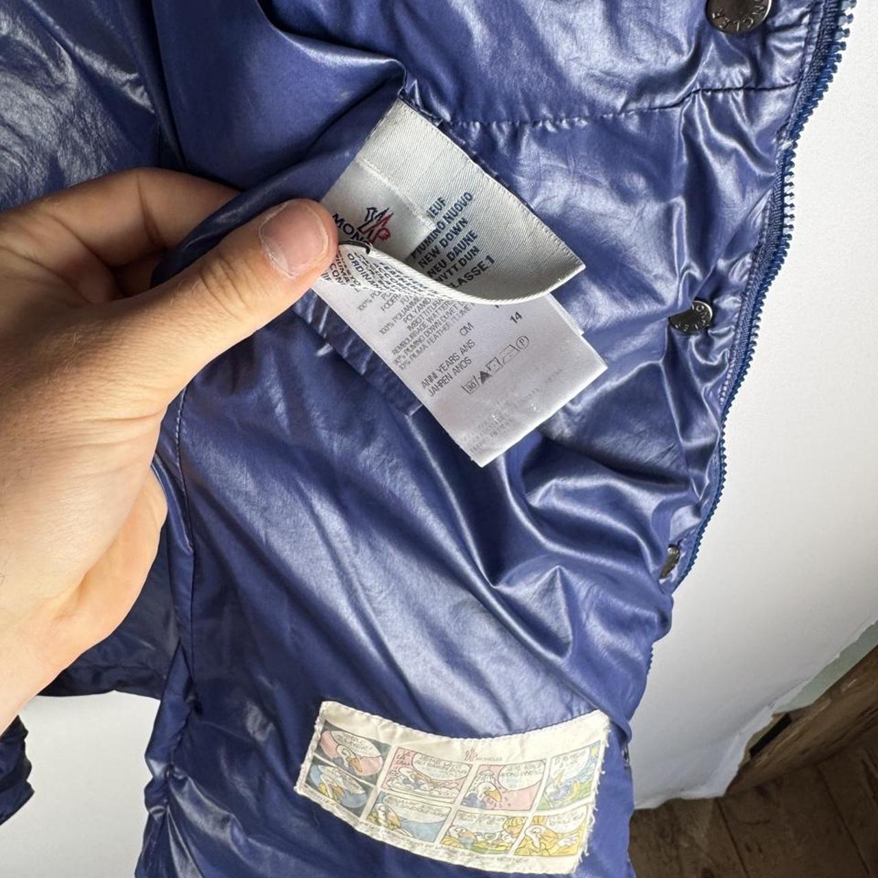Moncler blue puffer jacket with logo detail and quilted design.