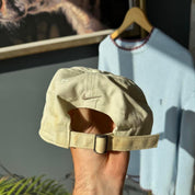 Nike cream cap with embroidered logo and adjustable strap.