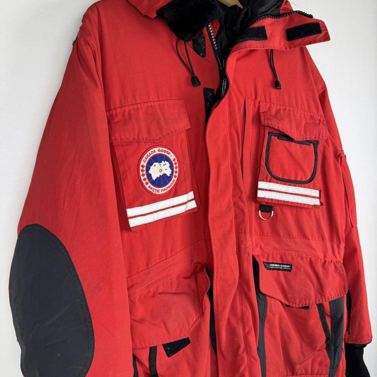 Canada Goose red parka jacket with logo patch and thick insulated material.