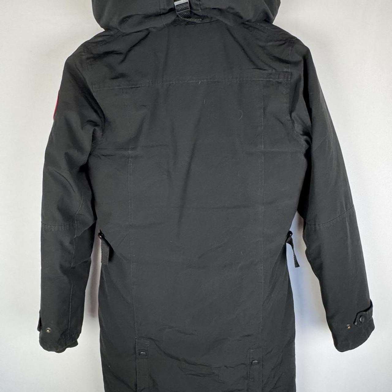 Canada Goose black parka jacket with logo patch and fur-lined hood.
