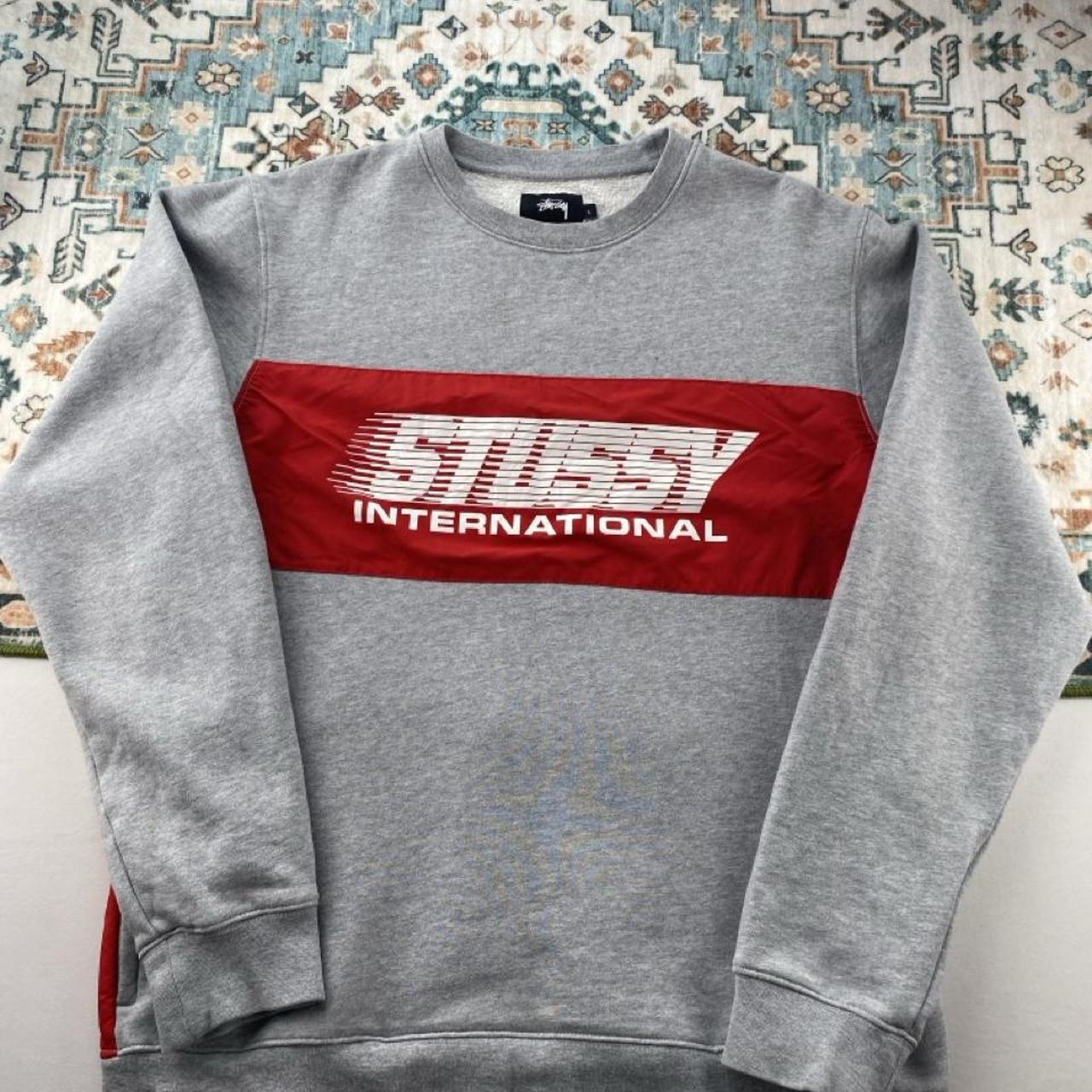 Stüssy grey sweatshirt featuring international logo and soft cotton material.