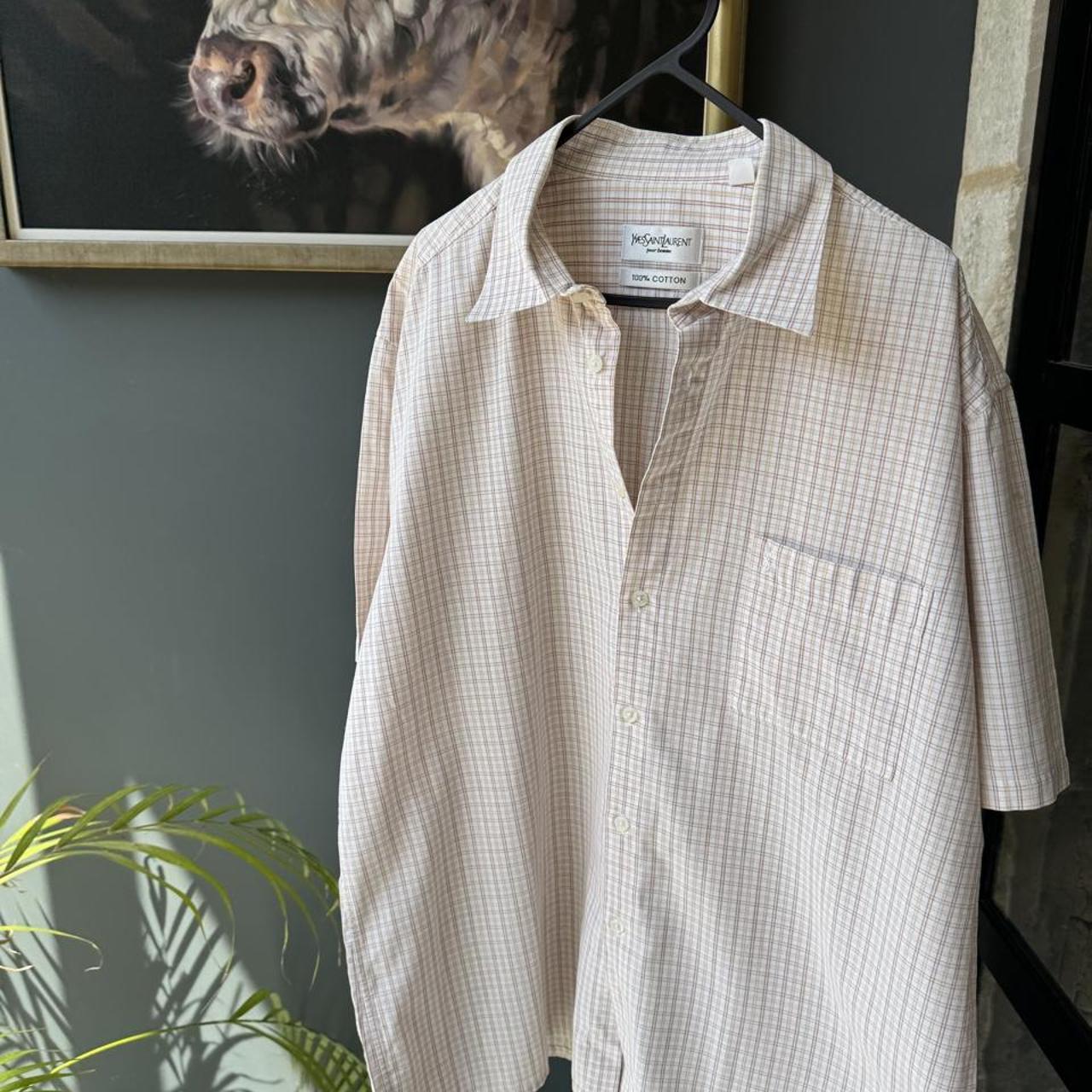 Yves Saint Laurent cream short sleeve shirt with embroidered YSL logo and button details.