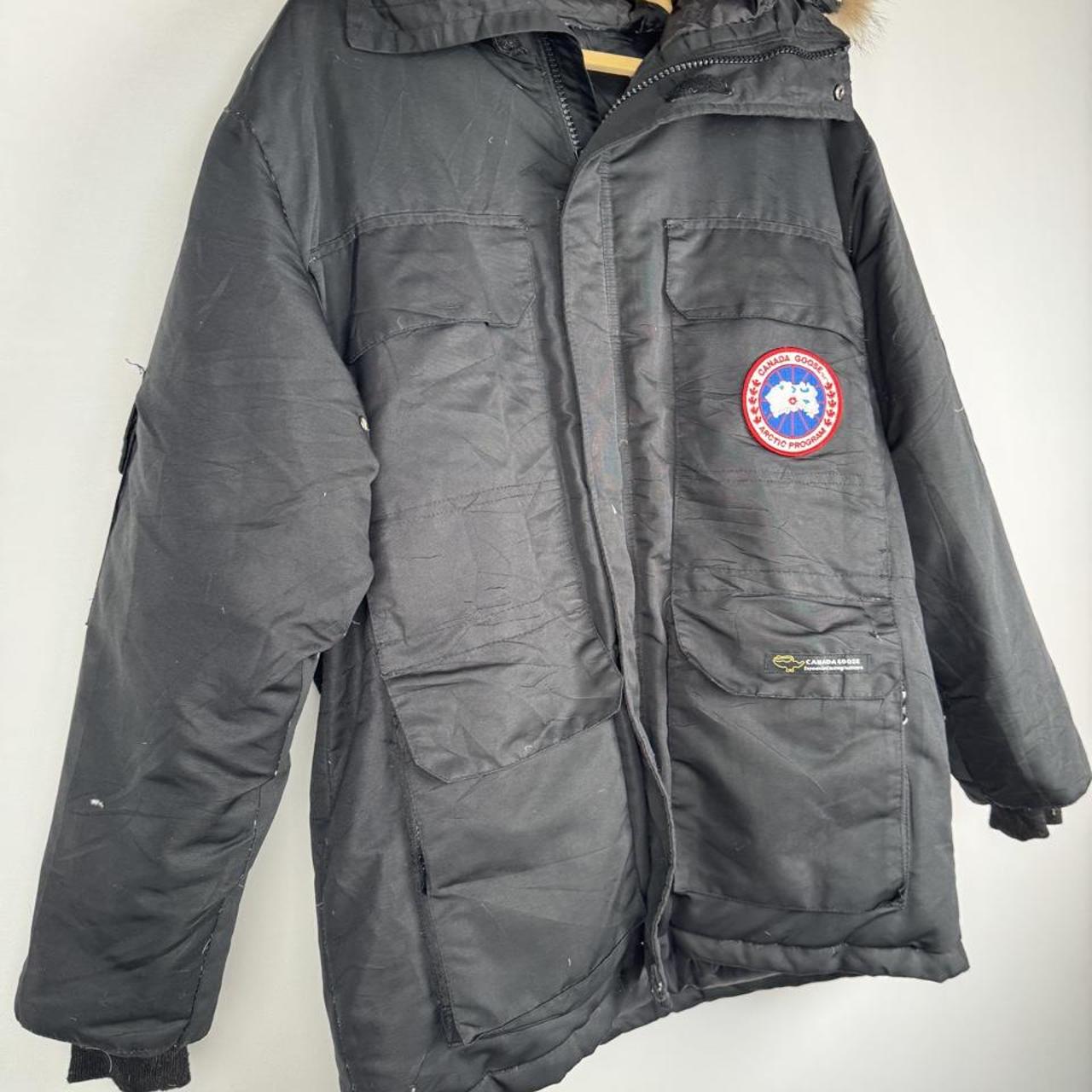 Canada Goose black and brown parka jacket with logo and utility pockets.