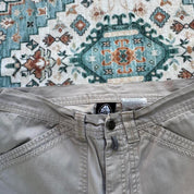 Nike ACG beige cargo pants with embroidered logo and multiple pockets.