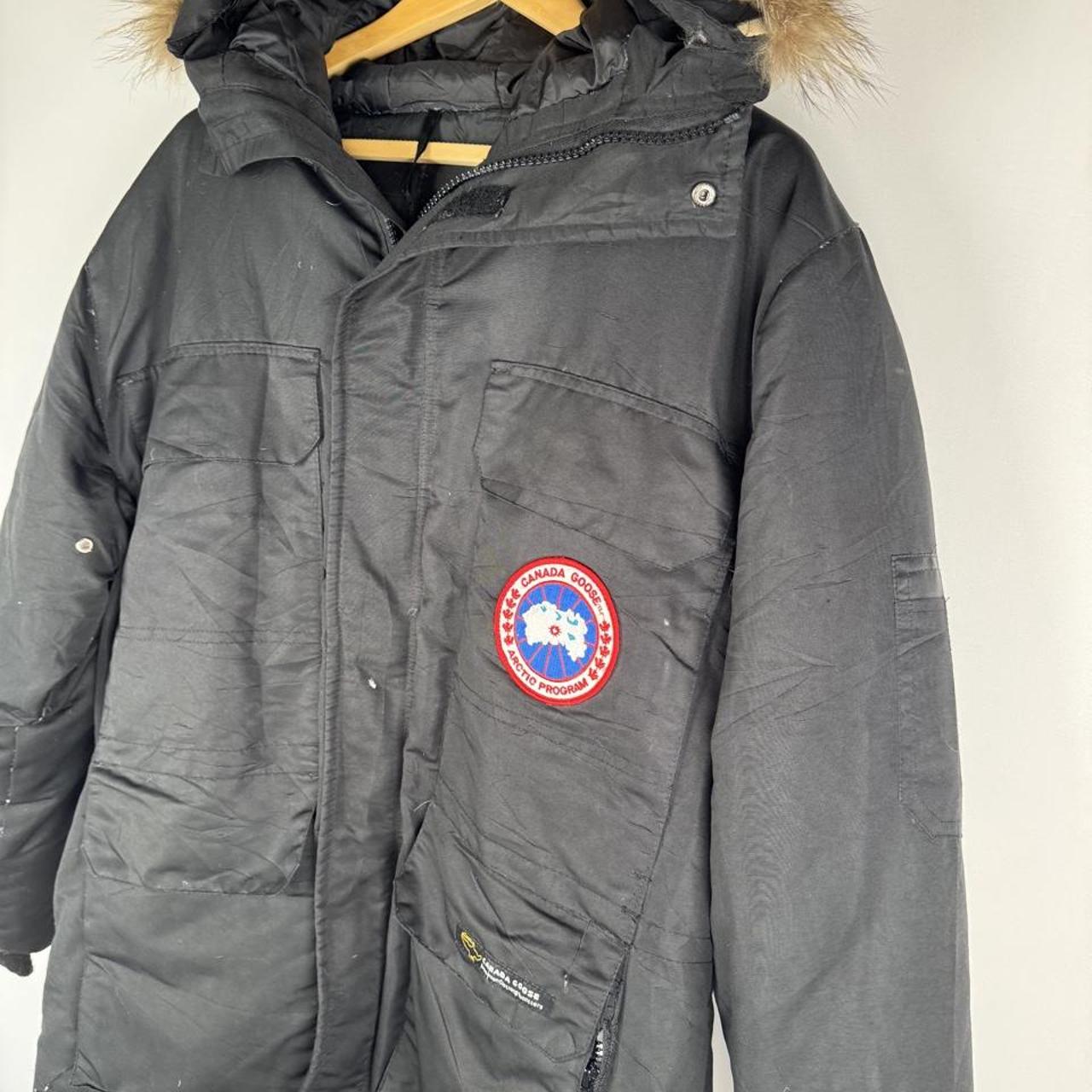 Canada Goose black and brown parka jacket with logo and utility pockets.