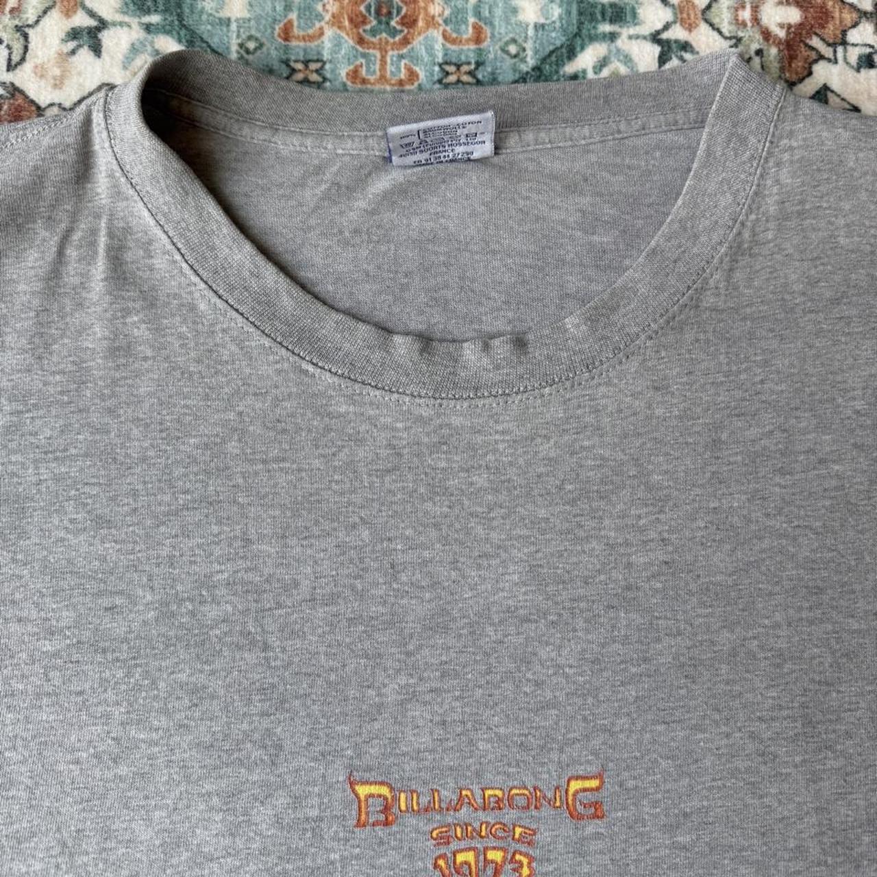 Billabong oversized graphic t-shirt blue with cream and green patterns, featuring pocket detail.