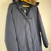 Canada Goose navy parka jacket with logo patch and fur-lined hood.