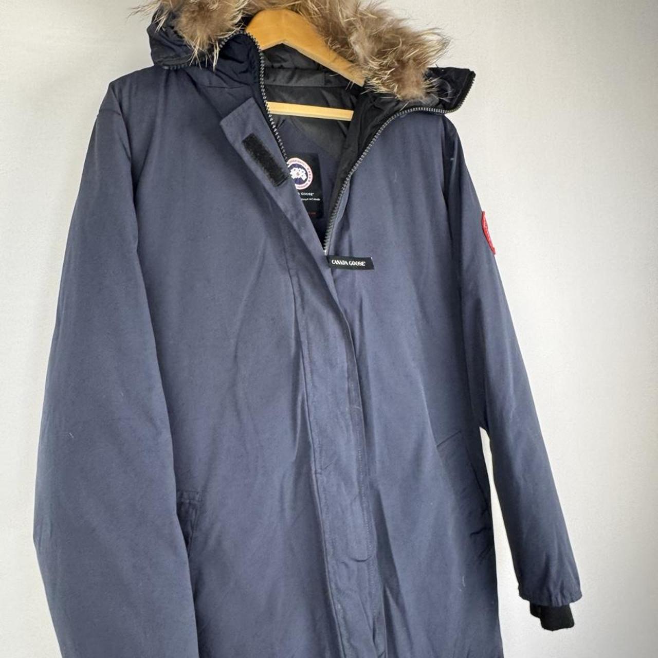 Canada Goose navy parka jacket with logo patch and fur-lined hood.