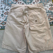 Quiksilver cream jorts with classic logo patch and vintage style from early 2000s.