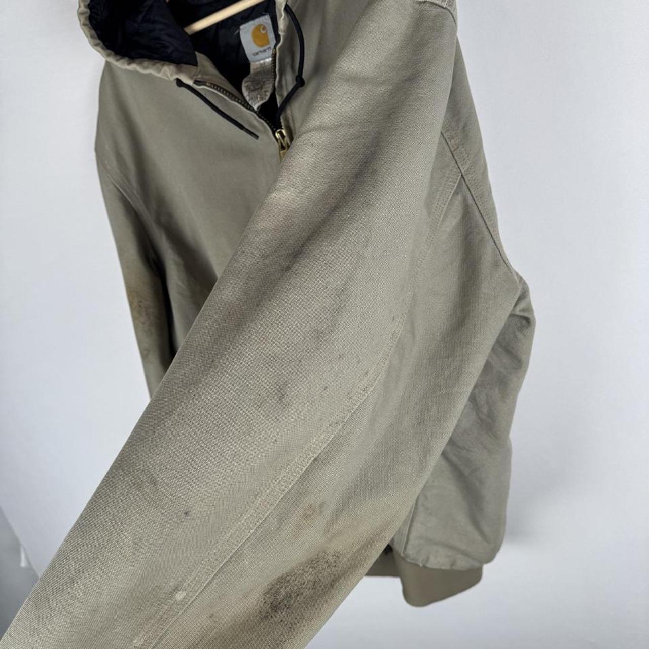 Carhartt active jacket, orange, oversized fit, visible logo, durable material.