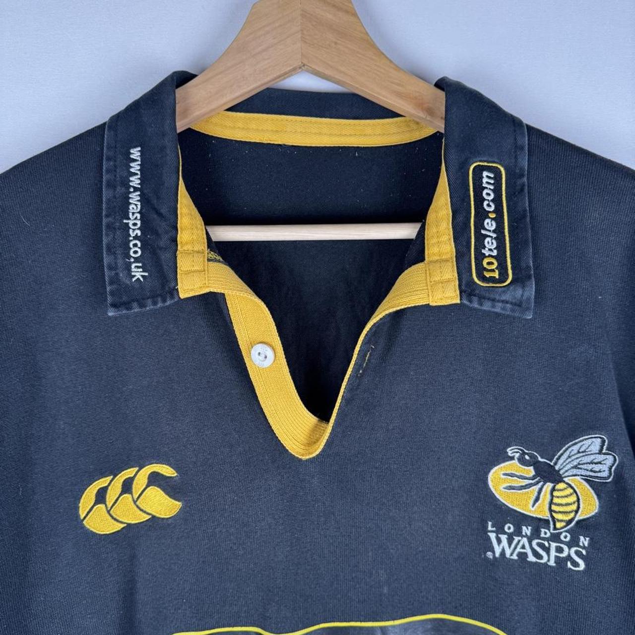 Canterbury men's rugby polo shirt, black and gold, featuring Wasps logo and classic design.