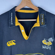 Canterbury men's rugby polo shirt, black and gold, featuring Wasps logo and classic design.