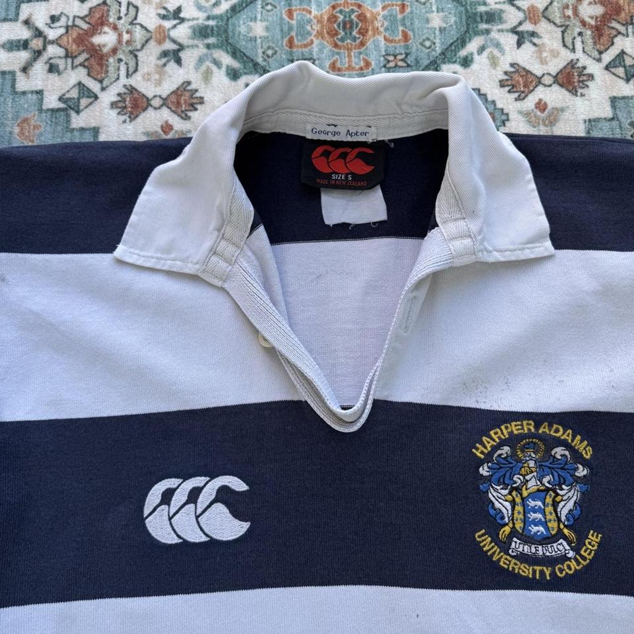 Canterbury men's rugby polo shirt, navy blue, featuring Harper Adams University logo and classic collar.