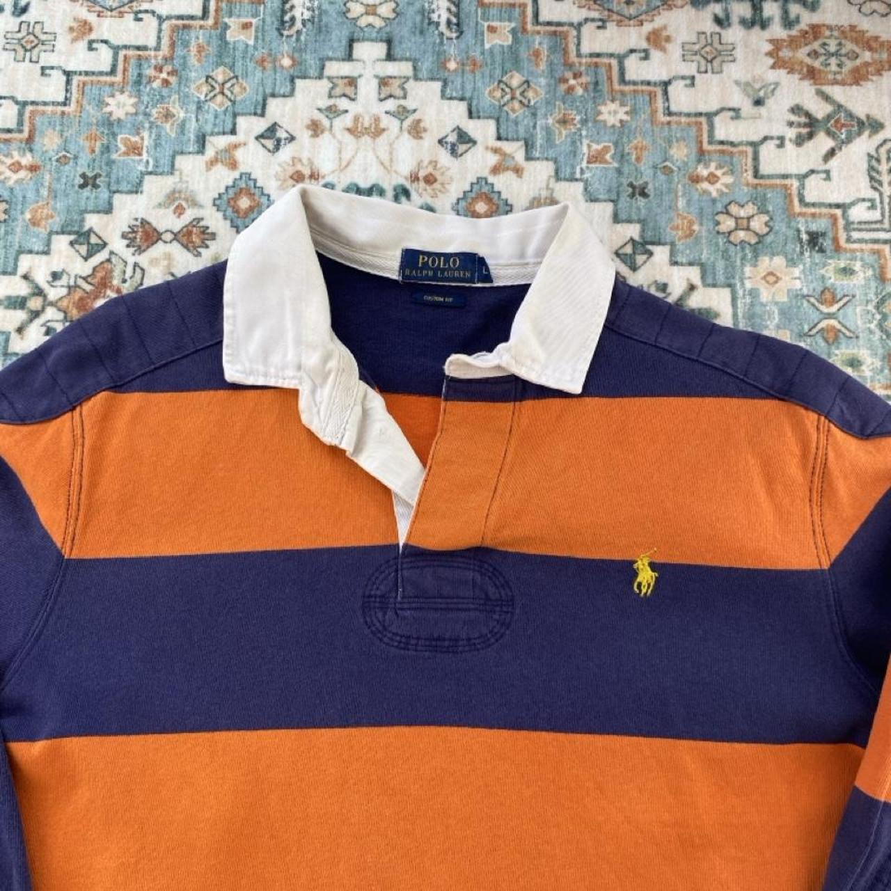 Polo Ralph Lauren navy and orange rugby polo shirt with thick stripes and embroidered logo.