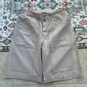 Nike ACG beige cargo pants with embroidered logo and multiple pockets.