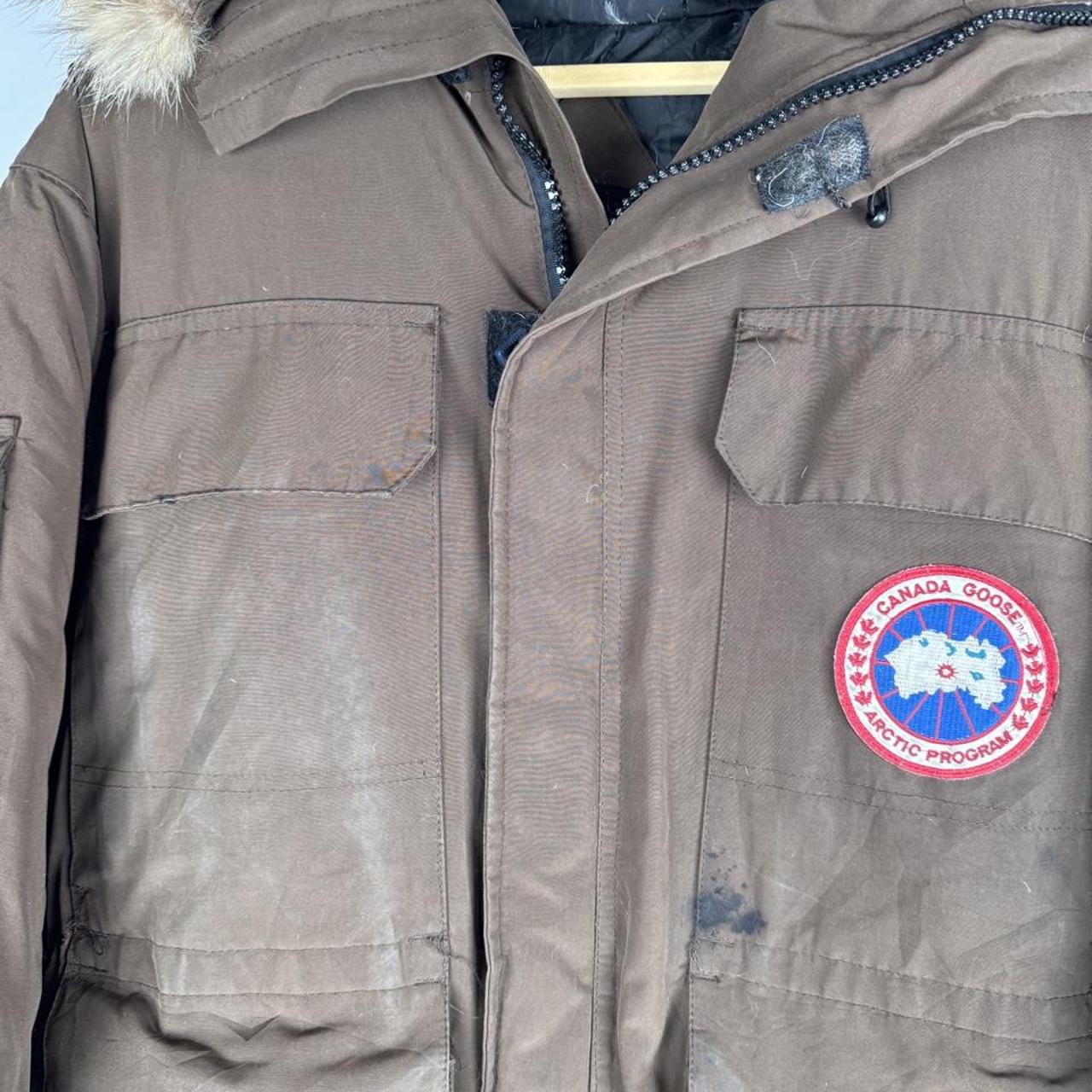 Canada Goose brown parka jacket with logo patch and utility pockets.