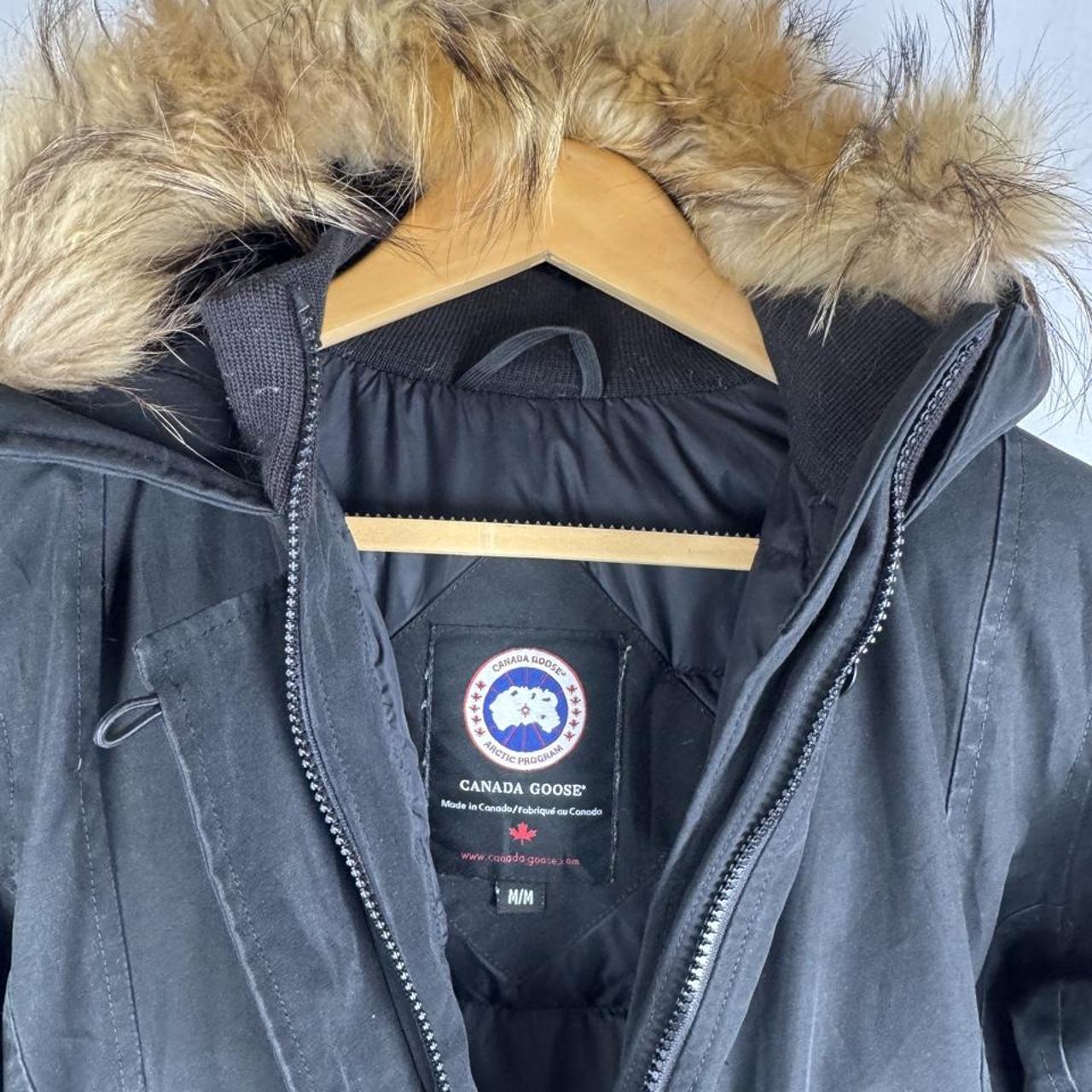 Canada Goose black parka jacket with logo patch and fur-lined hood.
