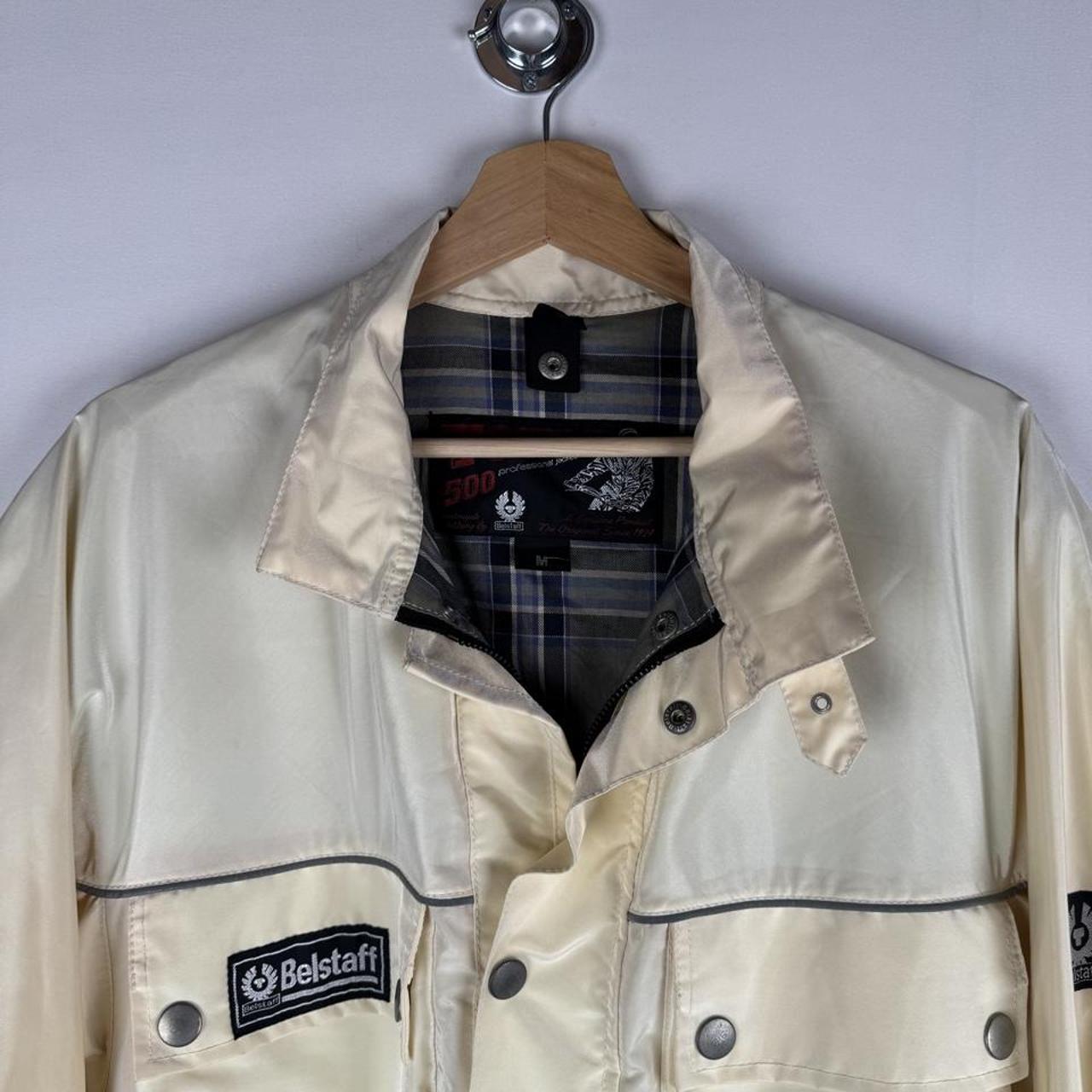 Belstaff cream motorcycle jacket with logo patch and shell material details.