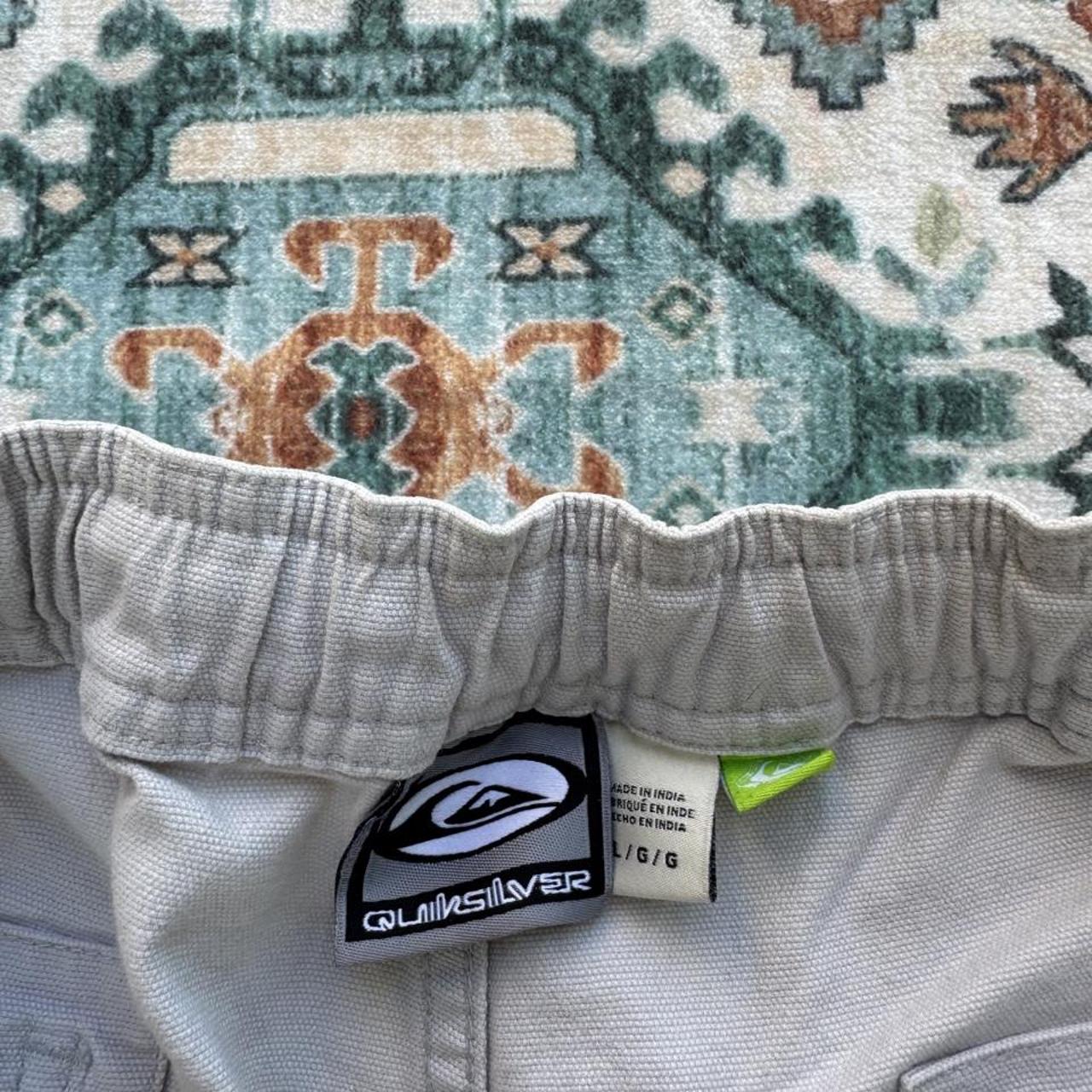 Quiksilver cream cargo shorts with embroidered logo and front pockets.