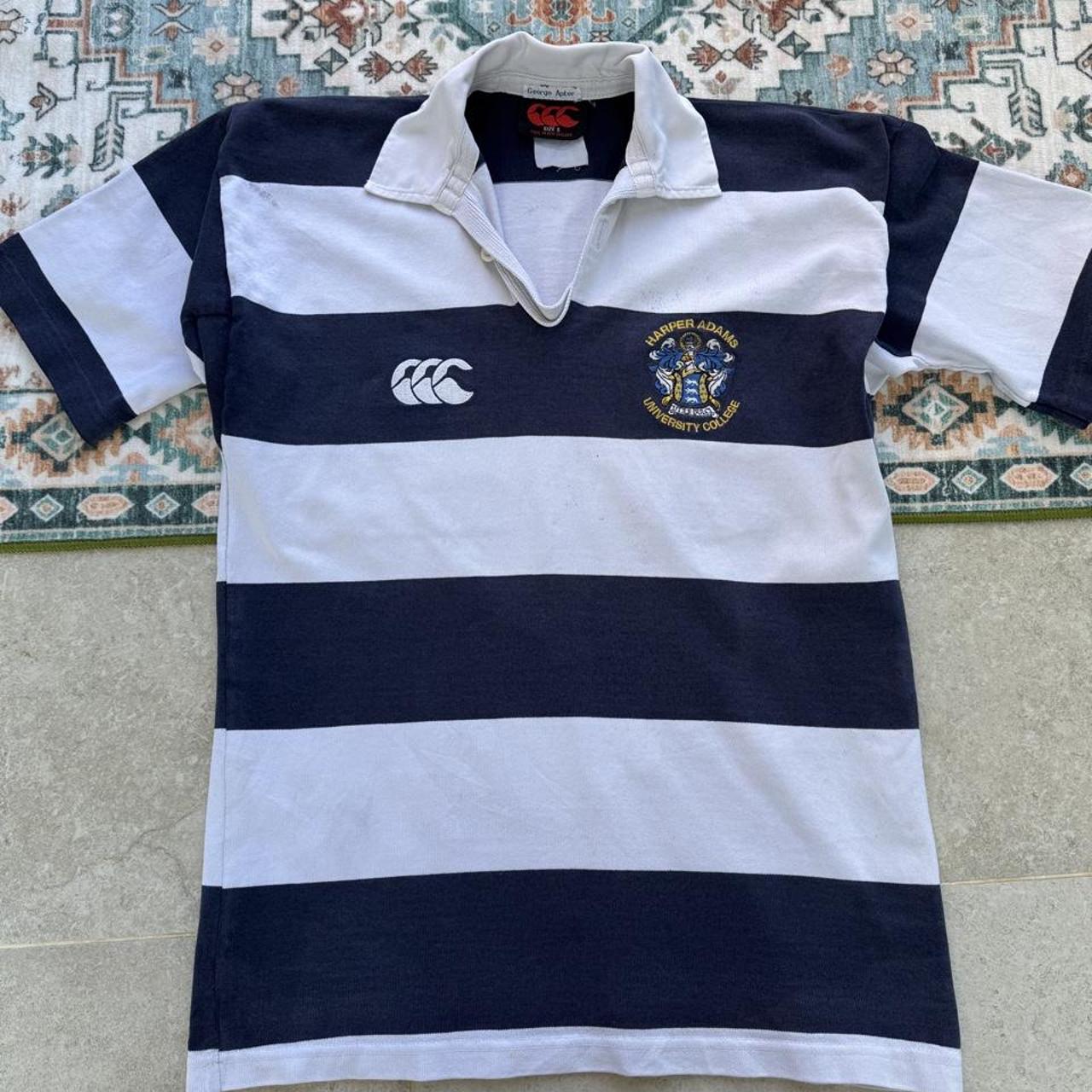 Canterbury men's rugby polo shirt, navy blue, featuring Harper Adams University logo and classic collar.