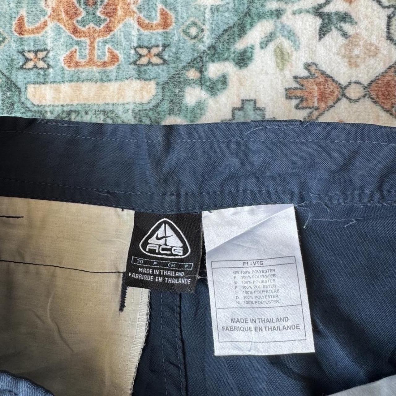 Nike ACG cargo shorts olive green with multiple pockets and logo patch detail.
