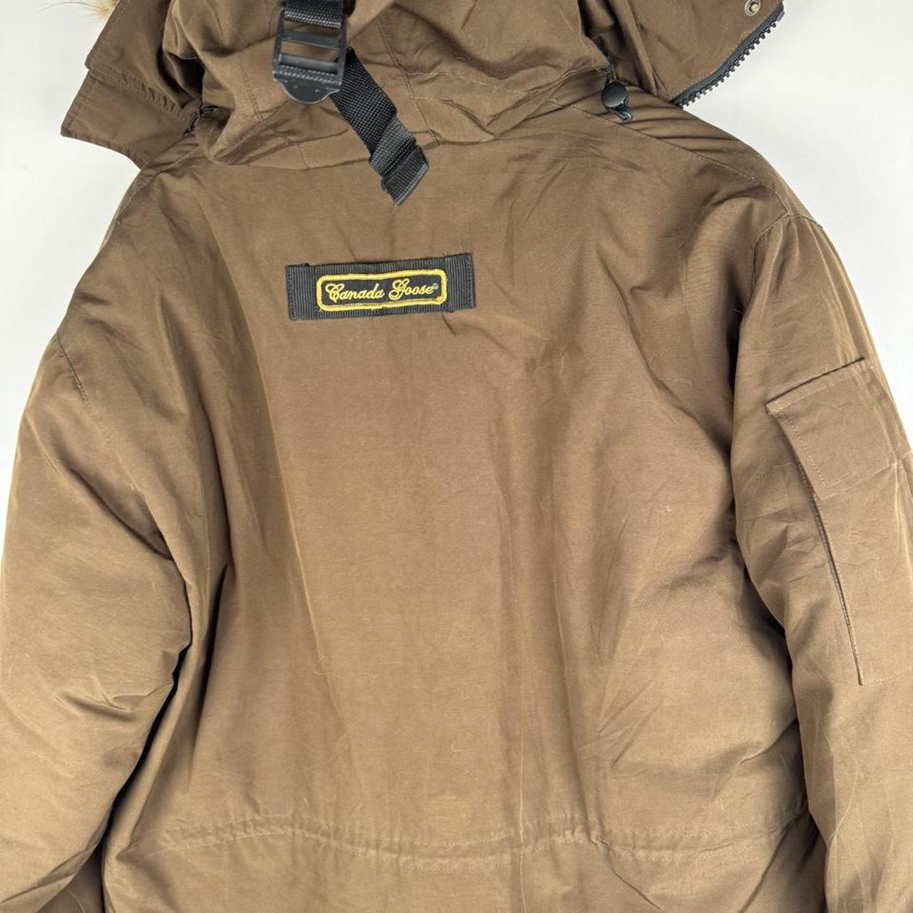 Canada Goose brown parka jacket with utility pockets and logo patch.