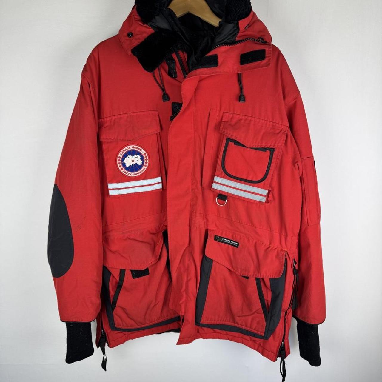 Canada Goose red parka jacket with logo patch and thick insulated material.