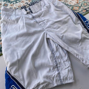 Billabong board shorts blue with tropical print and Andy Irons logo detail.