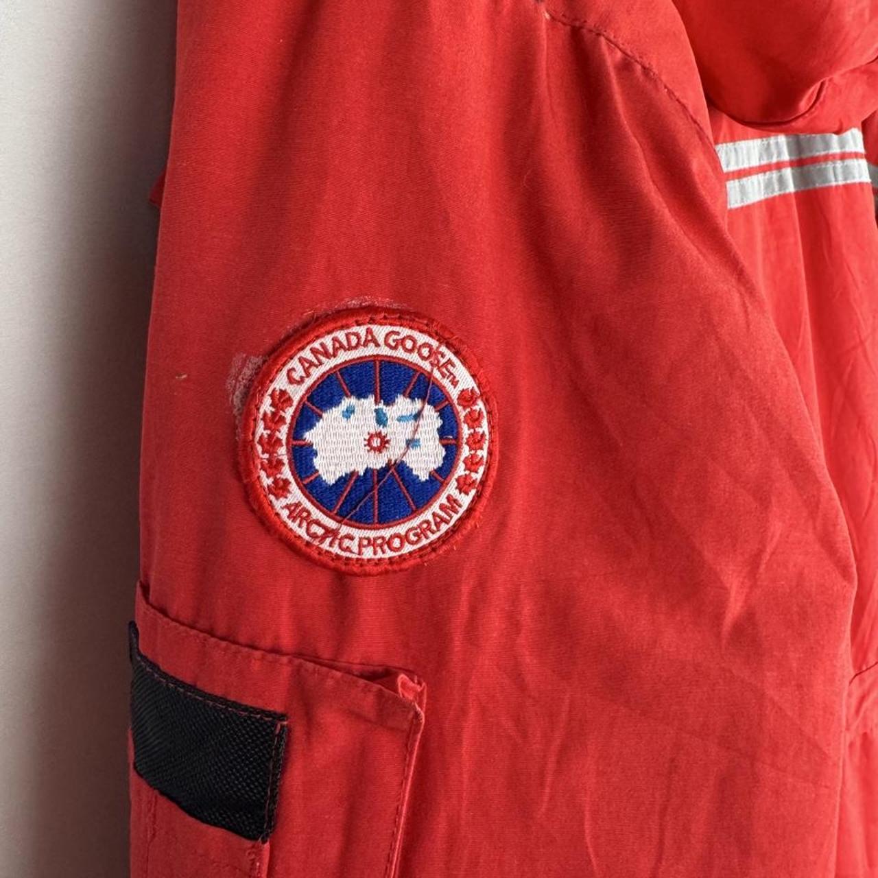 Canada Goose red parka jacket with logo patch and thick insulated material.