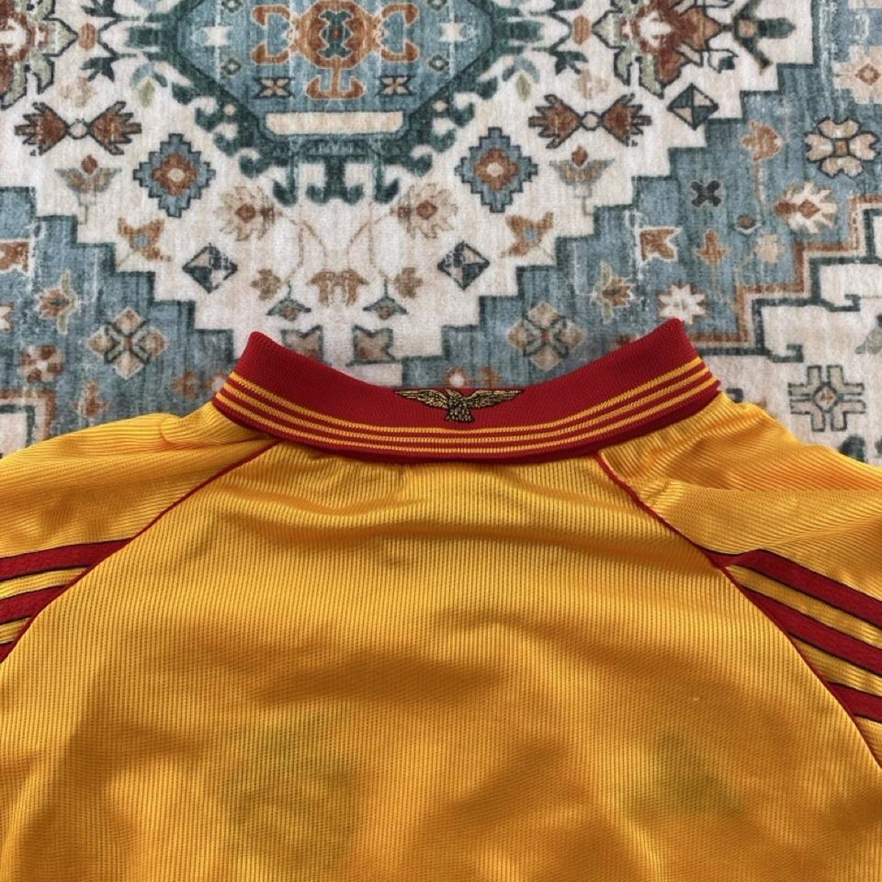 Adidas orange Benfica away jersey with embroidered logo and vintage design details.
