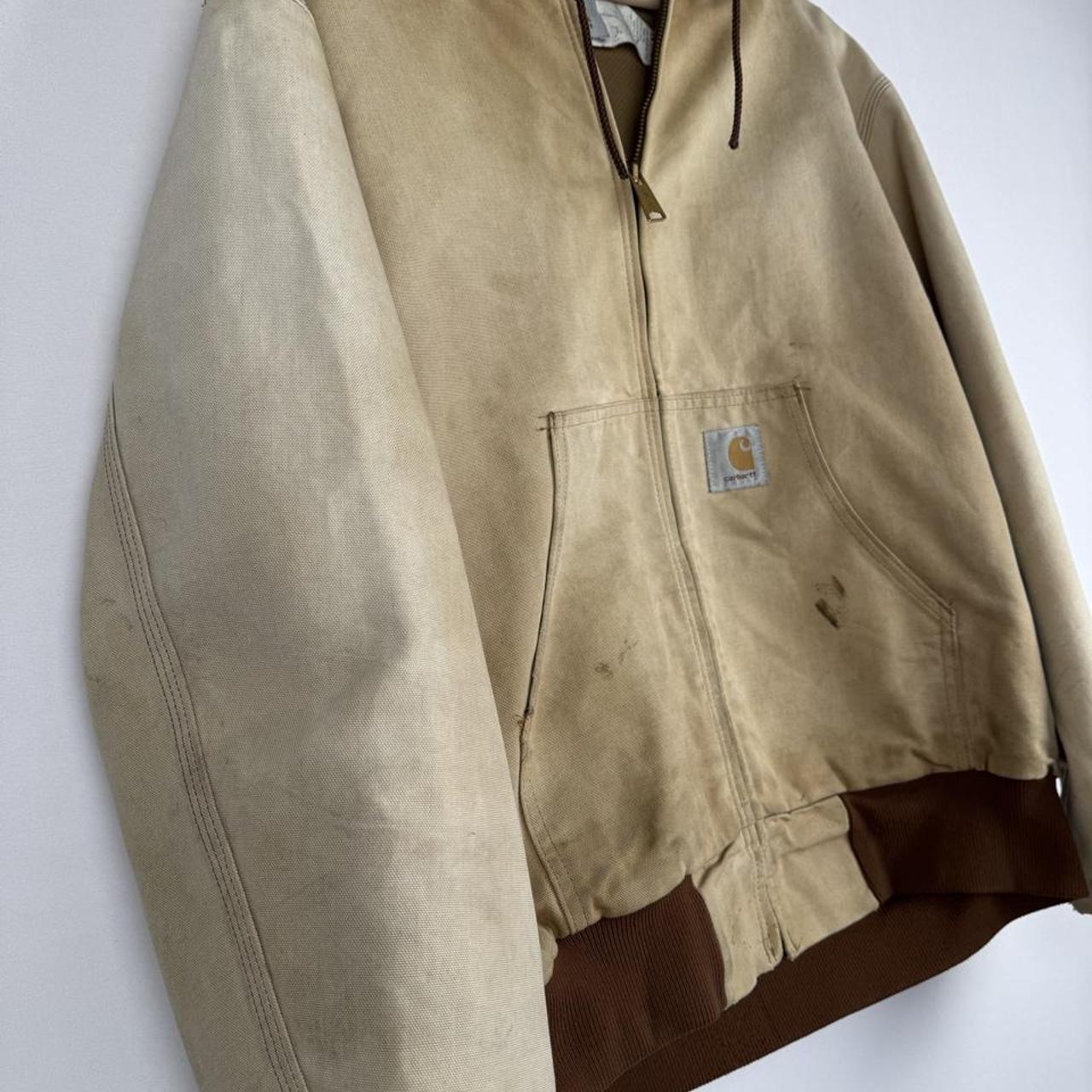 Carhartt cream distressed active jacket with logo patch and relaxed fit.