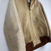 Carhartt cream distressed active jacket with logo patch and relaxed fit.