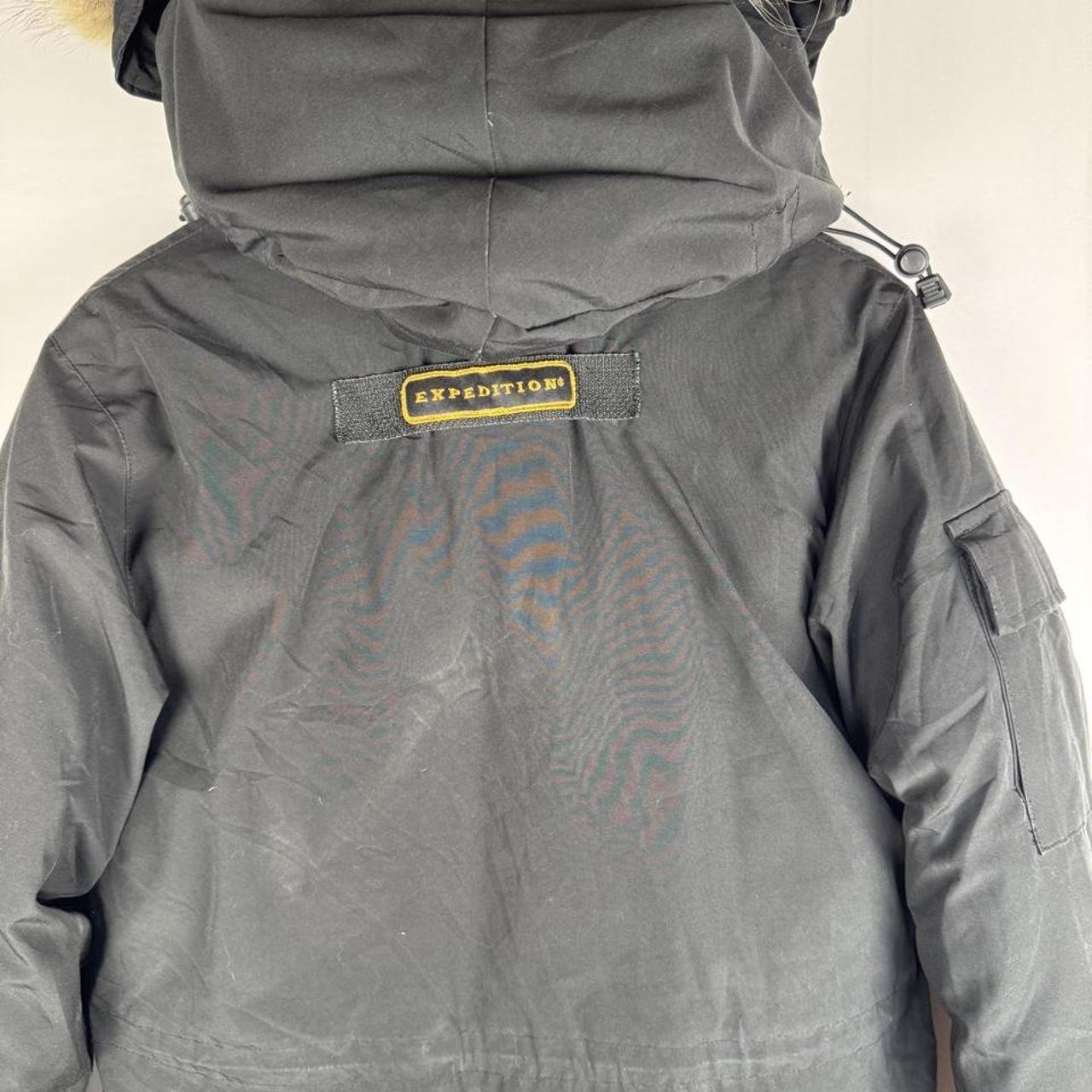 Canada Goose black parka jacket with logo patch and fur-lined hood.