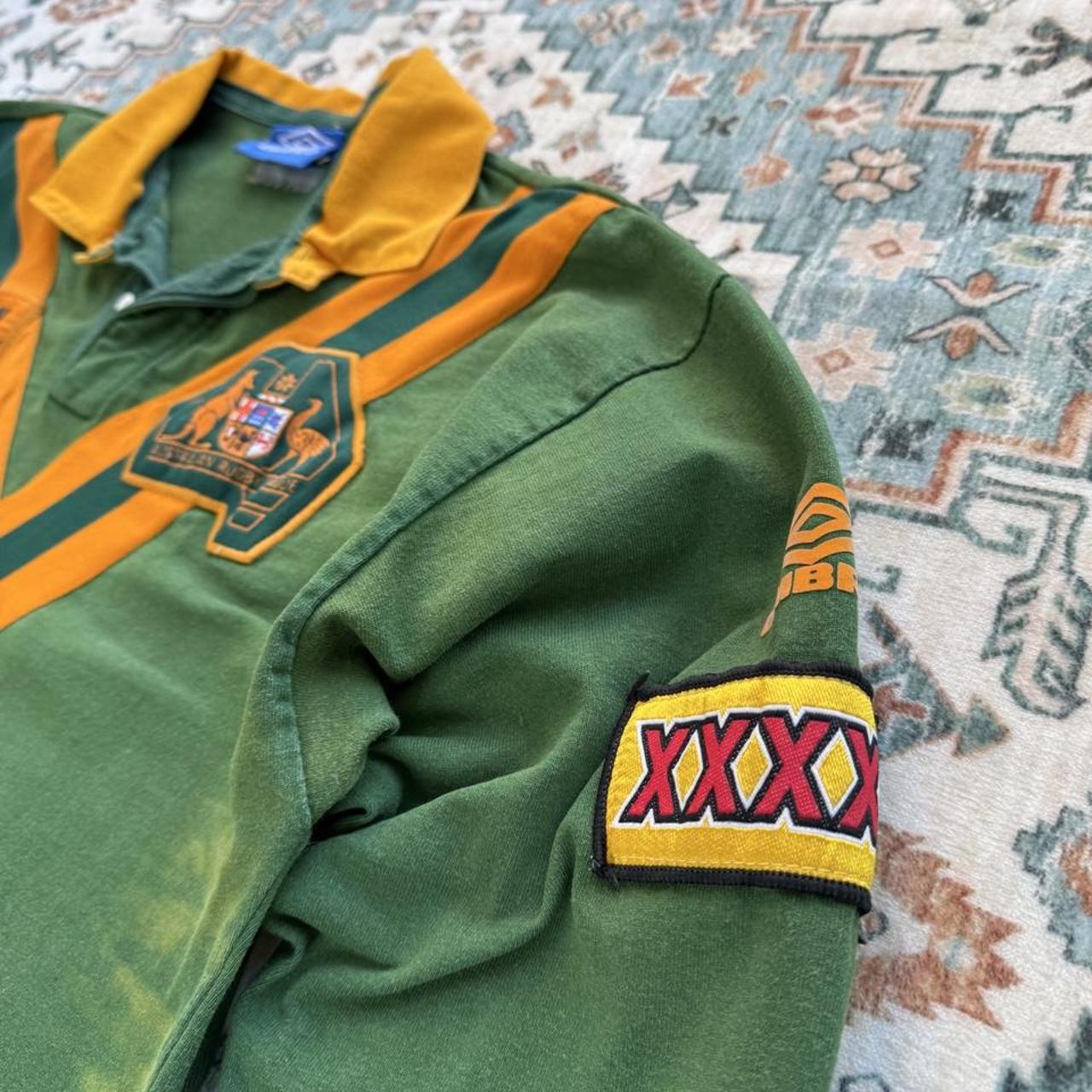 Umbro men's polo shirt green with Wallabies logo and rugby league pattern.