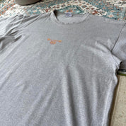 Billabong oversized graphic t-shirt blue with cream and green patterns, featuring pocket detail.